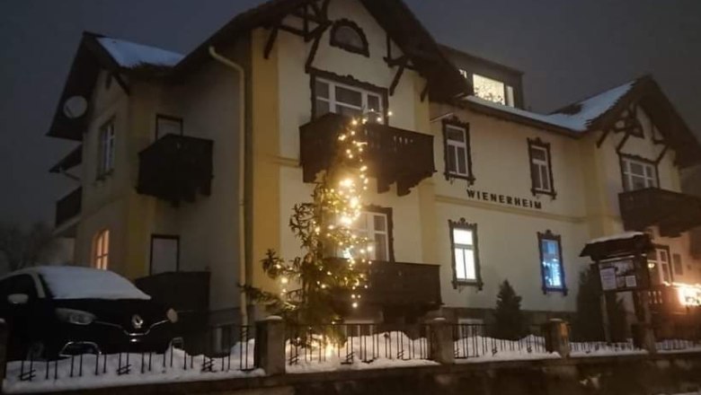 Ein beleuchtetes Gebäude im Schnee mit Weihnachtsdekoration.
