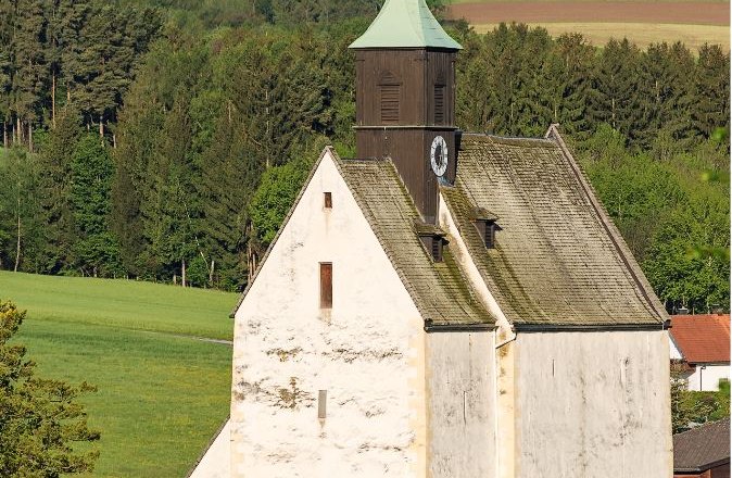 Wehrkirche Bad Schönau vor grüner Landschaft.