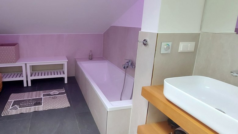 Badezimmer OG mit Farbwechsler, Badewanne, Waschbereich, Dusche und WC, © Bernadette Gierlinger
