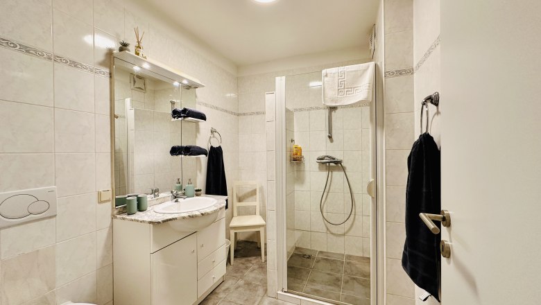 Modernes Badezimmer mit Dusche, Waschbecken und WC.