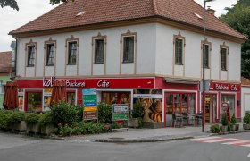 Ein zweistöckiges Gebäude mit einem Café und Bäckerei im Erdgeschoss in Pitten.