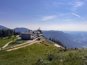 Raxalm-Berggasthof mit Bergpanorama im Hintergrund