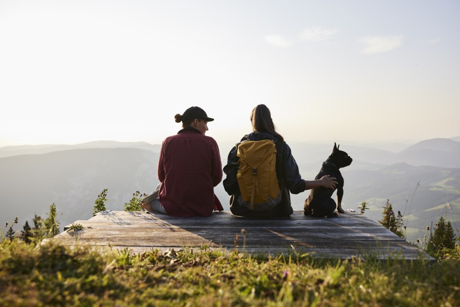 Zwei Frauen auf Aussichtbank mit Hund schauen vom Raxplateau in die Wiener Alpen
