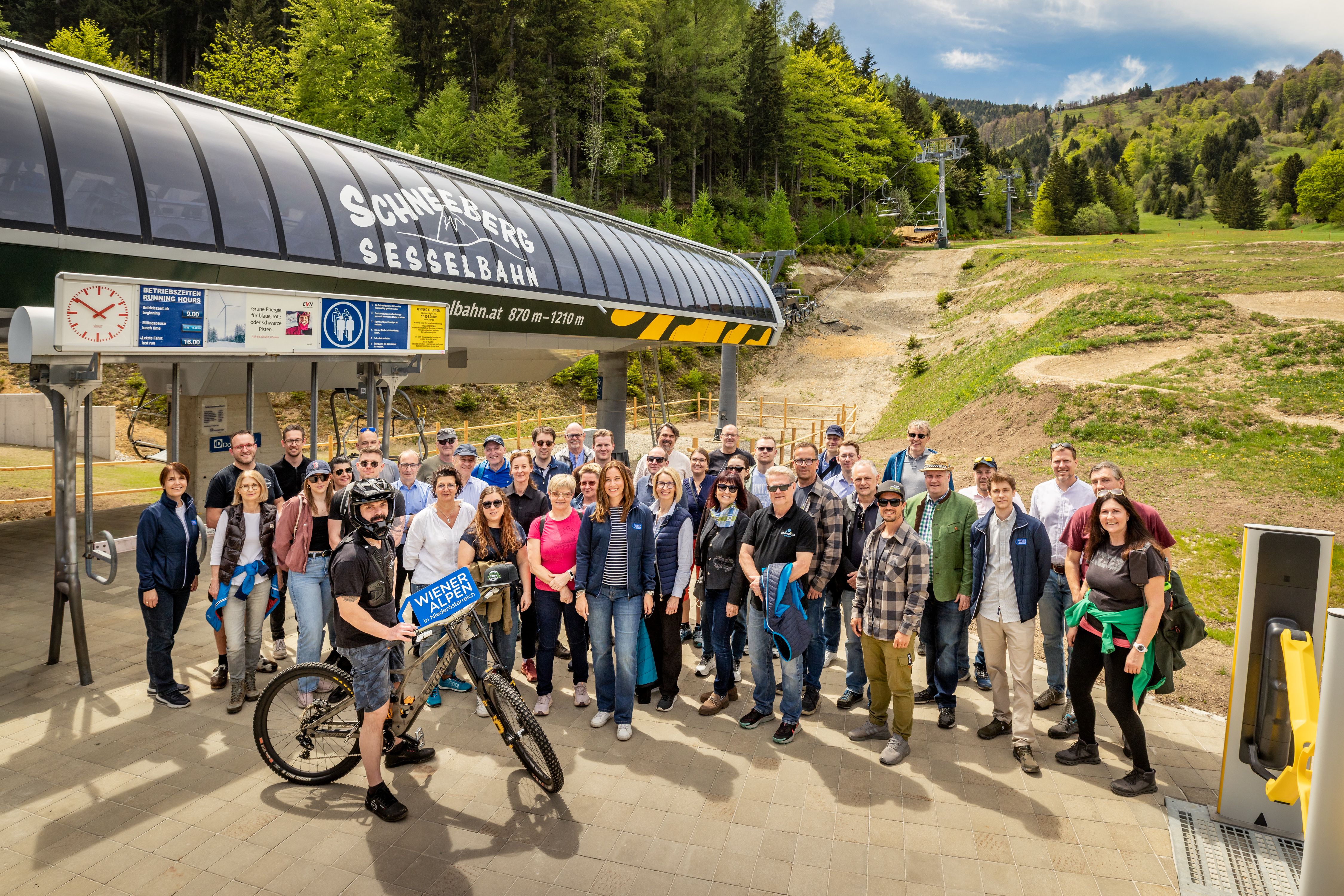 Rund 40 Personen stehen zu einem Gruppenfoto vor der Schneeberg-Sesselbahn Talstation zusammen.