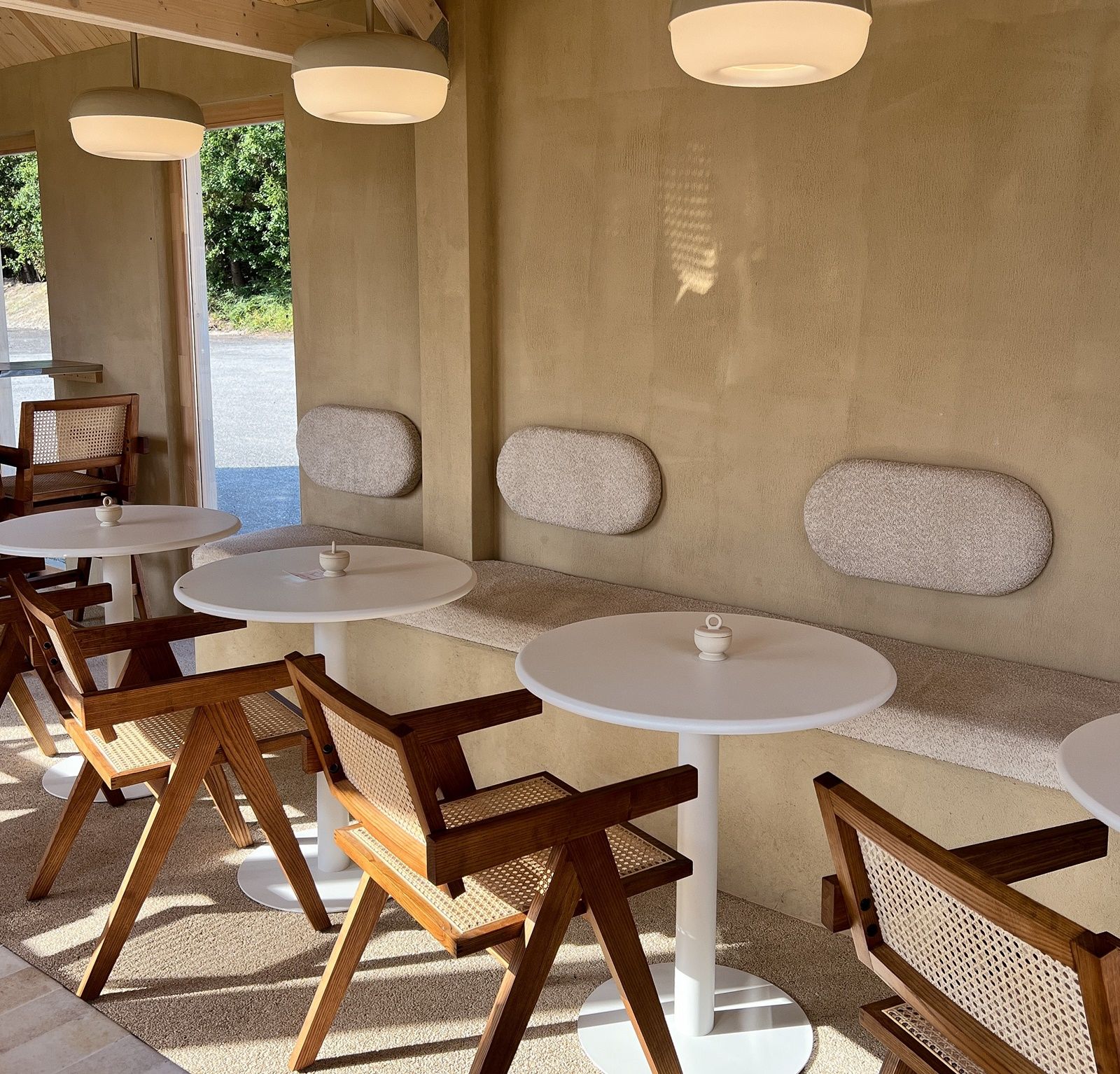 Innenbereich eines Cafés mit Holzmöbeln und runden Tischen.