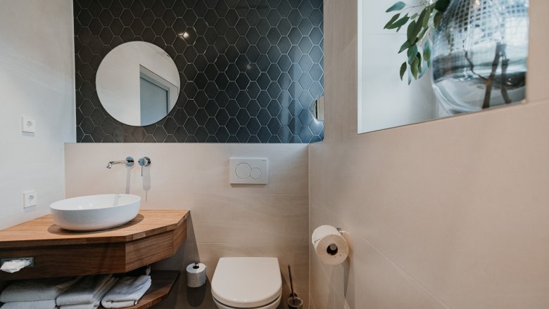 Modern bathroom with washbasin, mirror and toilet.