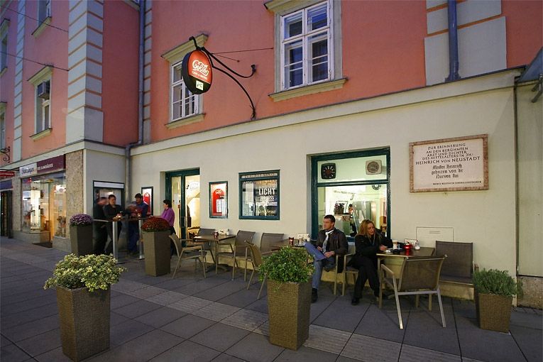 Straßencafé mit Menschen, die draußen sitzen.