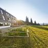 Naturfreundehaus Knofeleben in a sunny mountain landscape with solar panels on the roof.