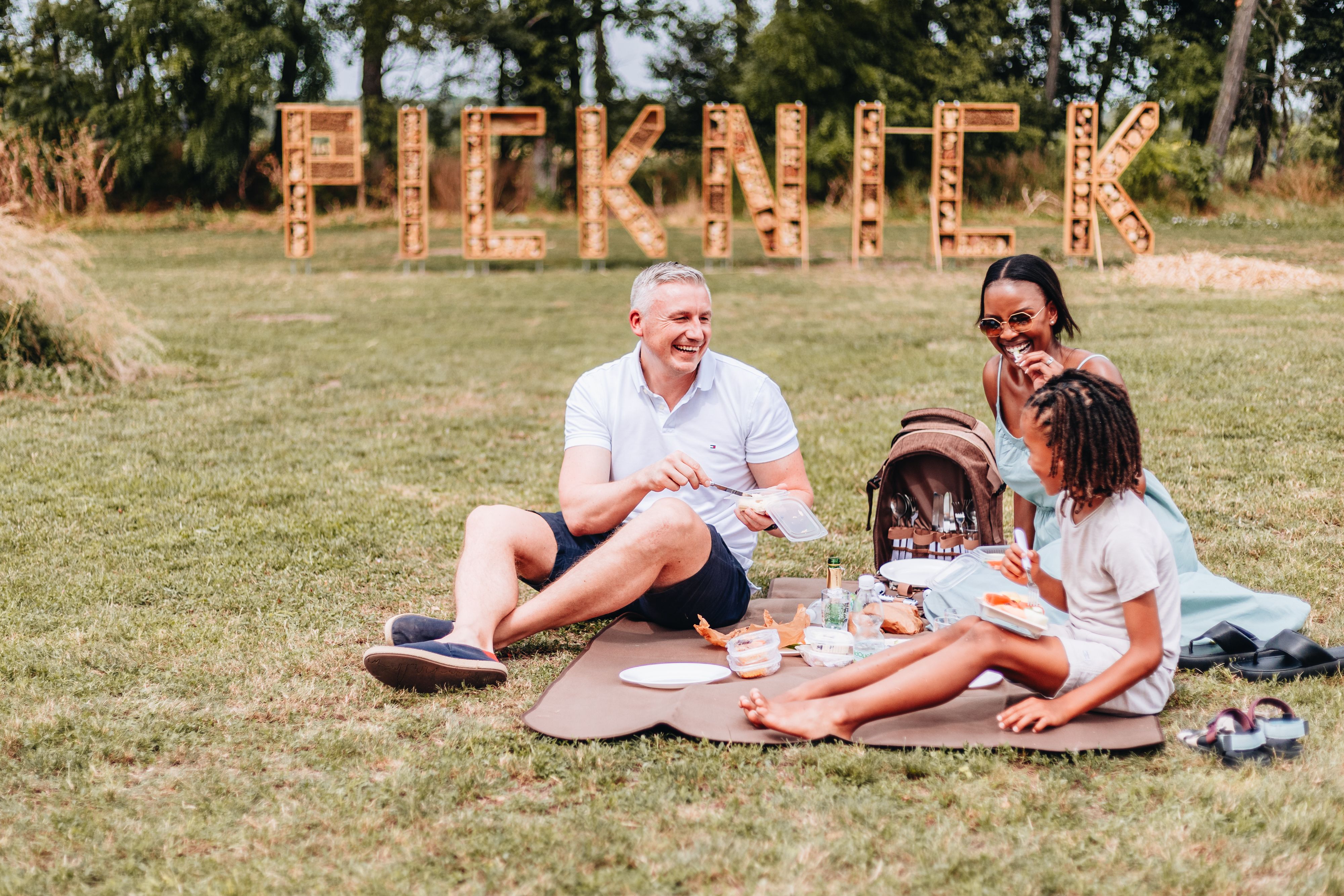 Menschen picknicken auf einer Wiese. 