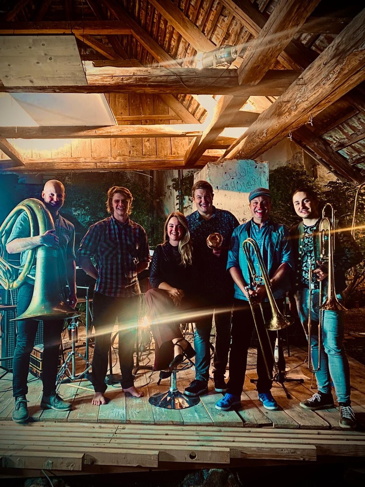 Sechs Personen einer Musikgruppe mit verschiedenen Instrumenten.