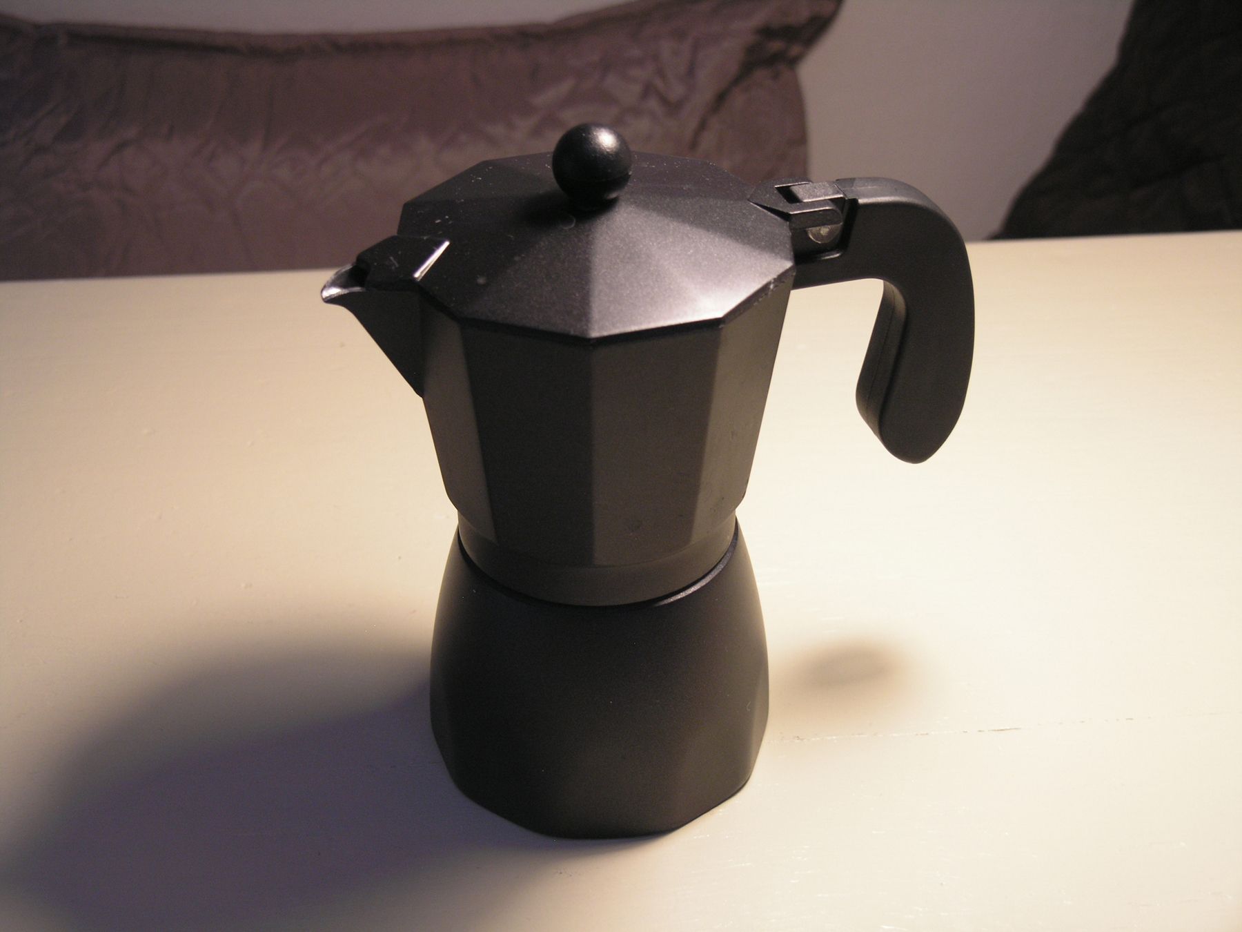 Eine schwarze Espressokanne auf einem Tisch.