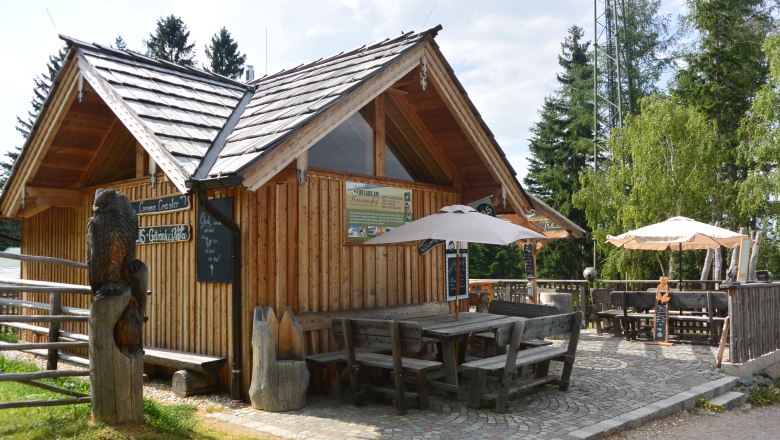 Holzhütte mit Terrasse und Sonnenschirmen im Freien.