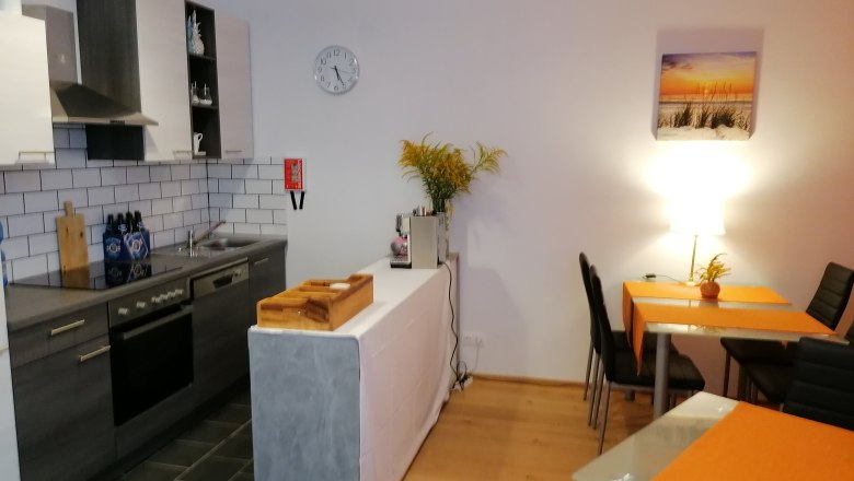 Modern kitchen with dining table and orange placemats.