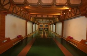 Innenansicht einer traditionellen Kegelbahn mit Holzelementen und zwei Bahnen.