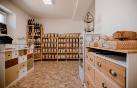 Interior view of an organic farm store with shelves full of products and a counter with bread.