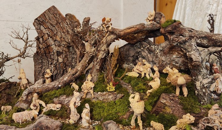 A nativity scene landscape made of roots and moss with small figures.