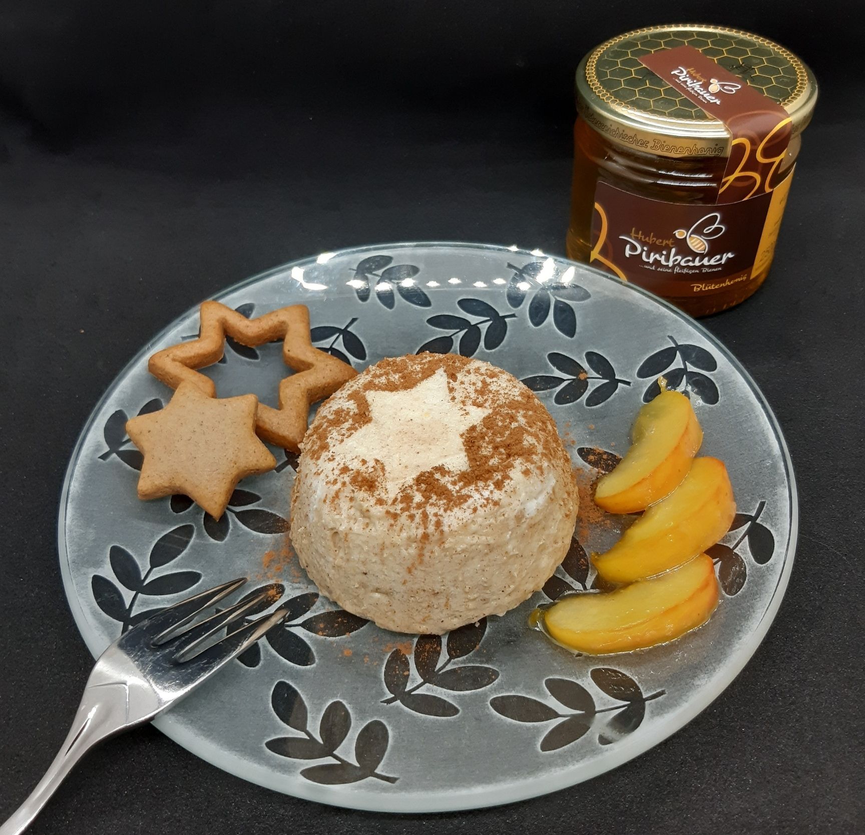 Teller mit Lebkuchenmousse, Apfelspalten und Lebkuchen, daneben ein Honigglas und eine Gabel.