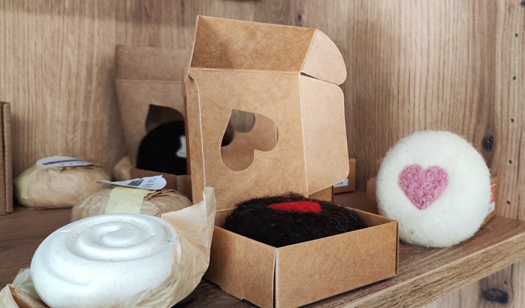 Handgemachte Seifen und Deko mit Herzmotiven in einem Regal.