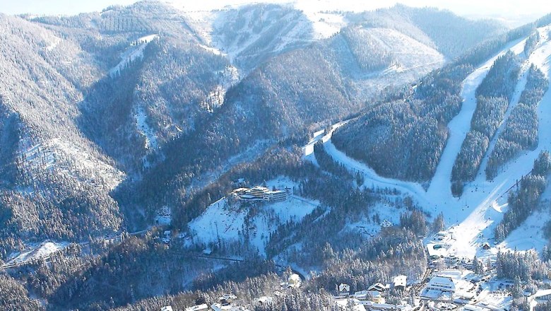 Aerial view of snow-covered mountains and a hotel in the Semmering region.
