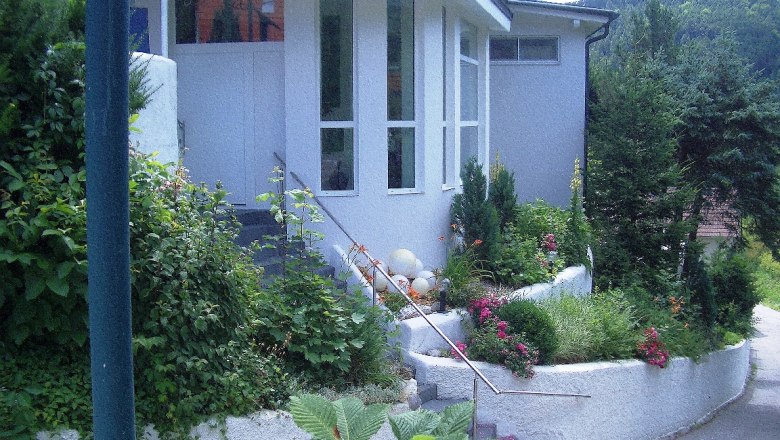 Eingang eines modernen Gebäudes mit Garten und Treppe.