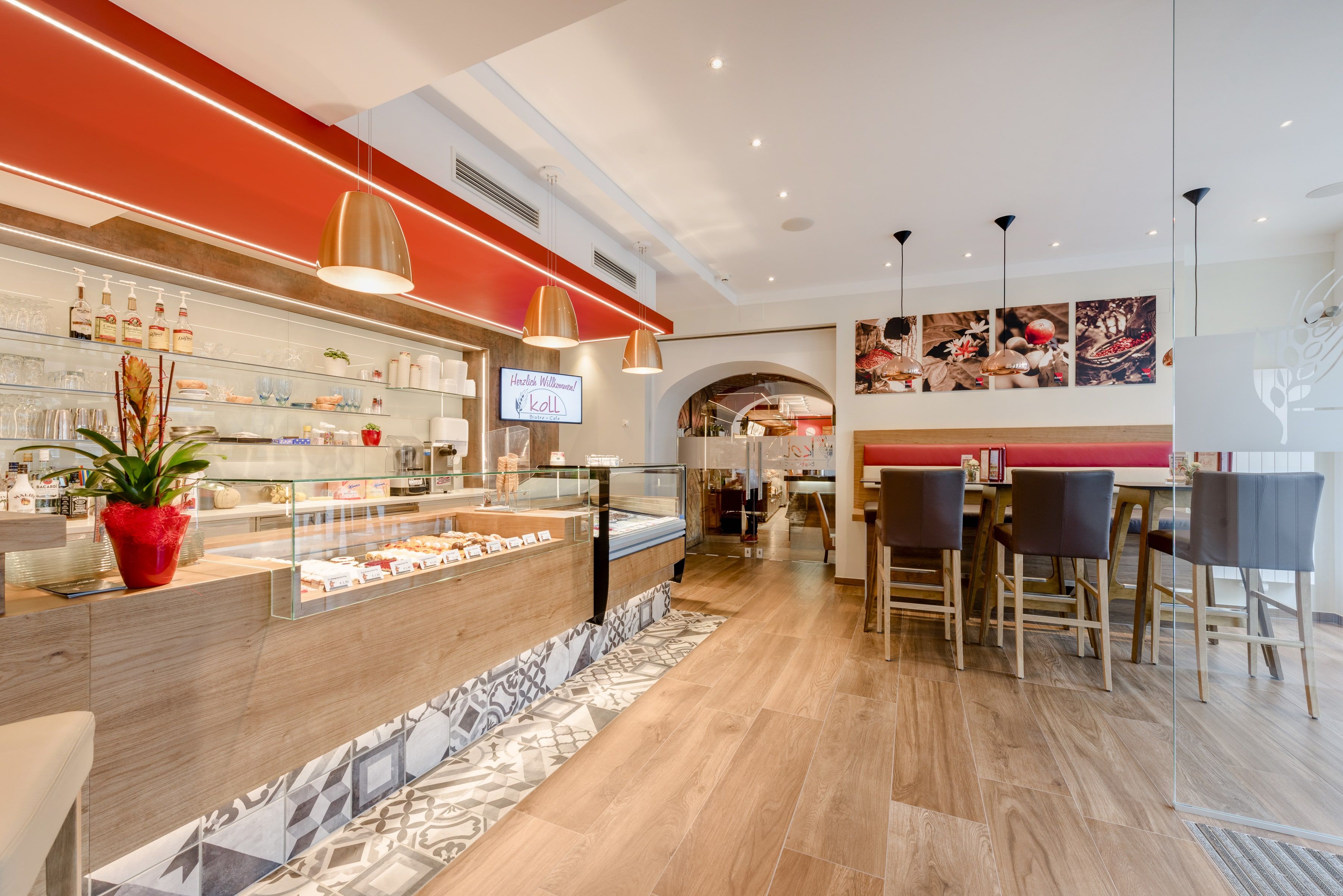 Innenansicht eines modernen Bistros mit Theke, Sitzbereich und dekorativen Elementen.