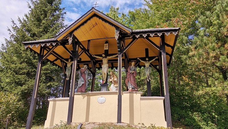 Kalvarienberg mit Kreuzigungsgruppe unter einem überdachten Pavillon.