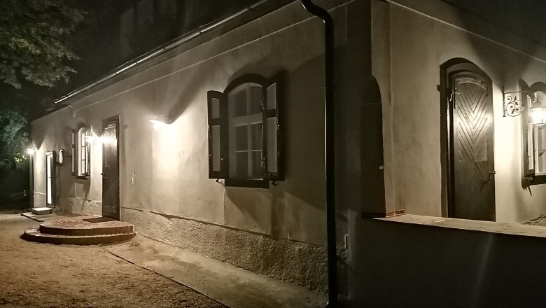 Illuminated building at night with open windows and doors.