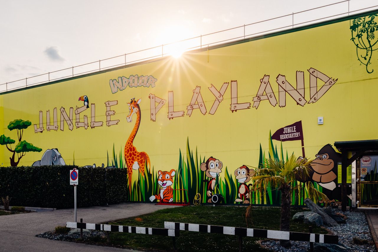 Exterior view of the yellow facade featuring animals and a jungle