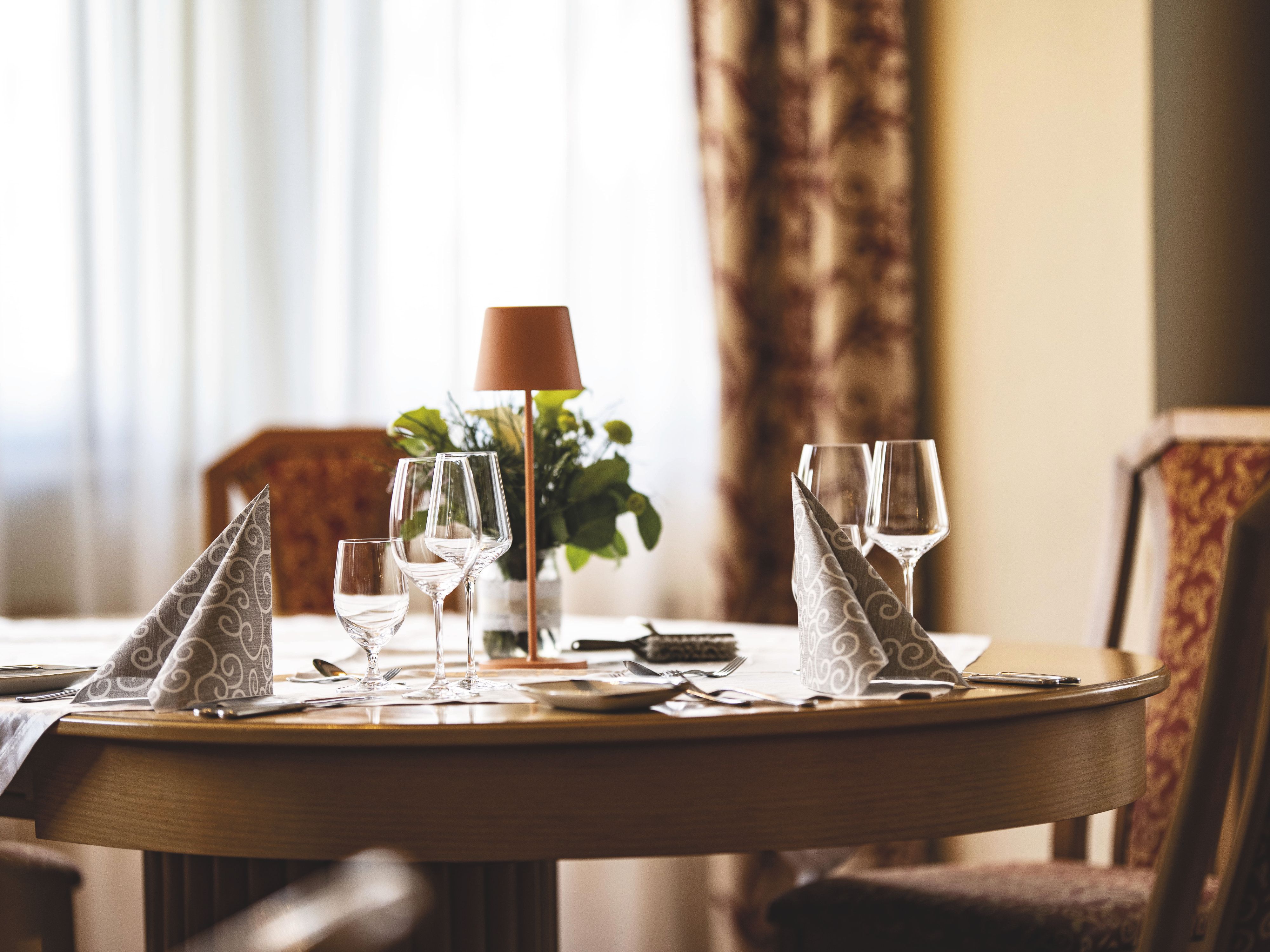 Eleganter gedeckter Tisch mit Weingläsern und Servietten in einem Restaurant.