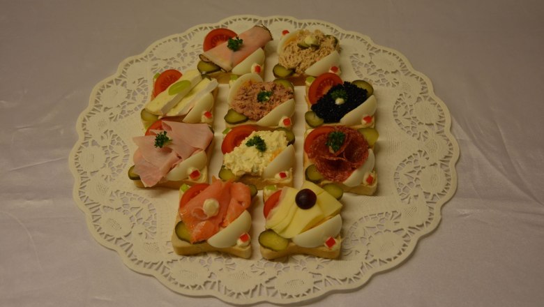A plate of sandwiches on a lace tablecloth.