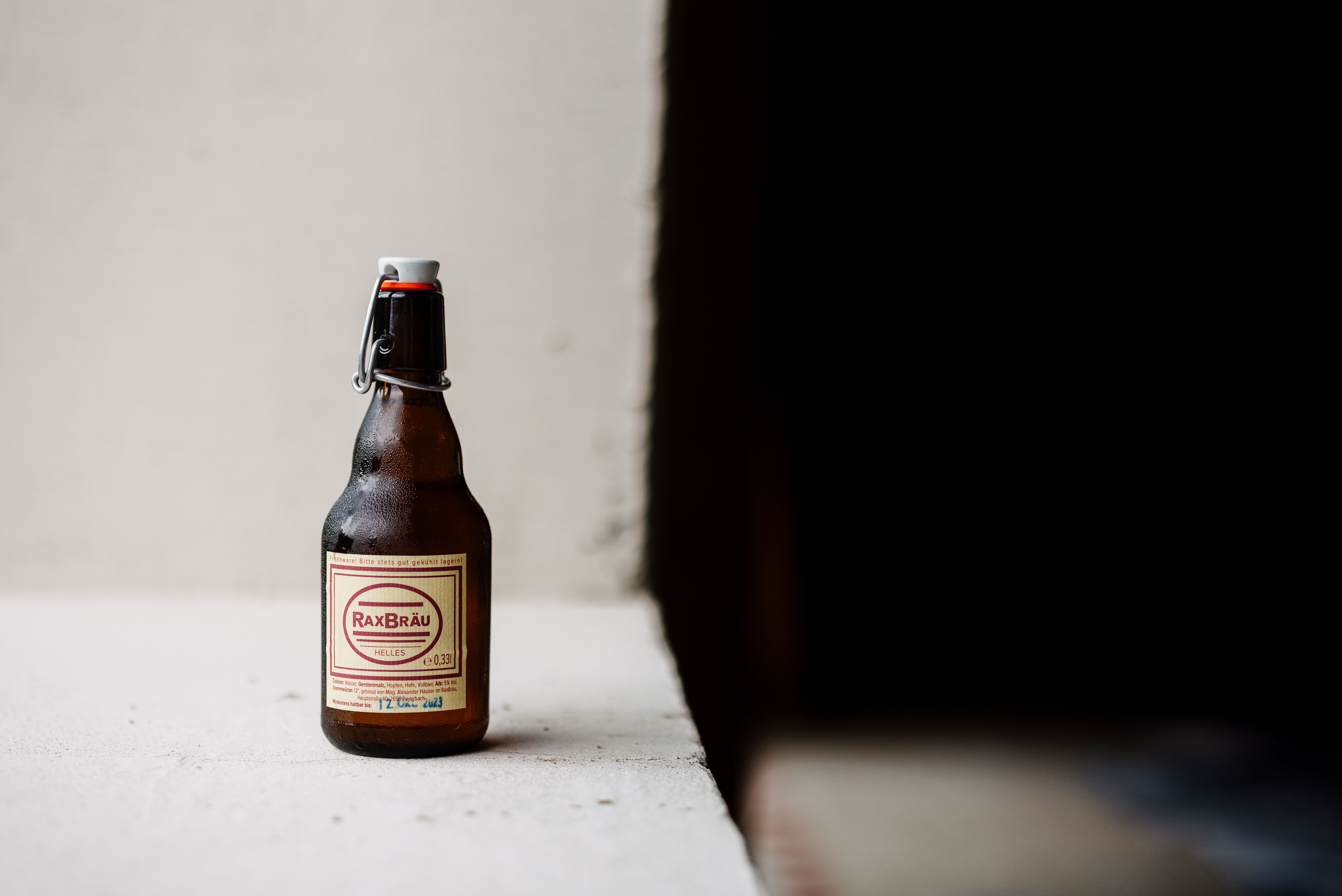 Ein kühles, erfrischendes Bier in Bio-Qualität steht bereit, um den Gaumen zu verwöhnen. Die sanften Hügel der Wiener Alpen im Hintergrund laden zu einem entspannten Genussmoment ein. Hier, wo Natur und Kulinarik aufeinandertreffen, wird jeder Schluck zum Erlebnis.