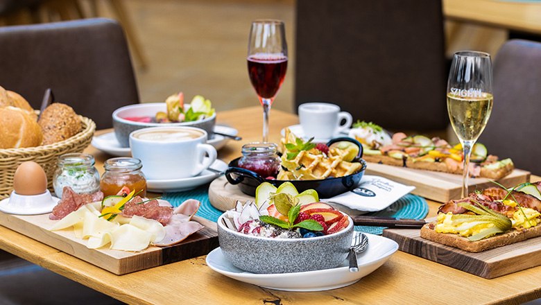 Frühstückstisch mit verschiedenen Speisen, Sektgläsern und Kaffee.