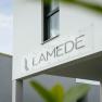 Modern building exterior with the lettering 'LAMEDE' on a sign.