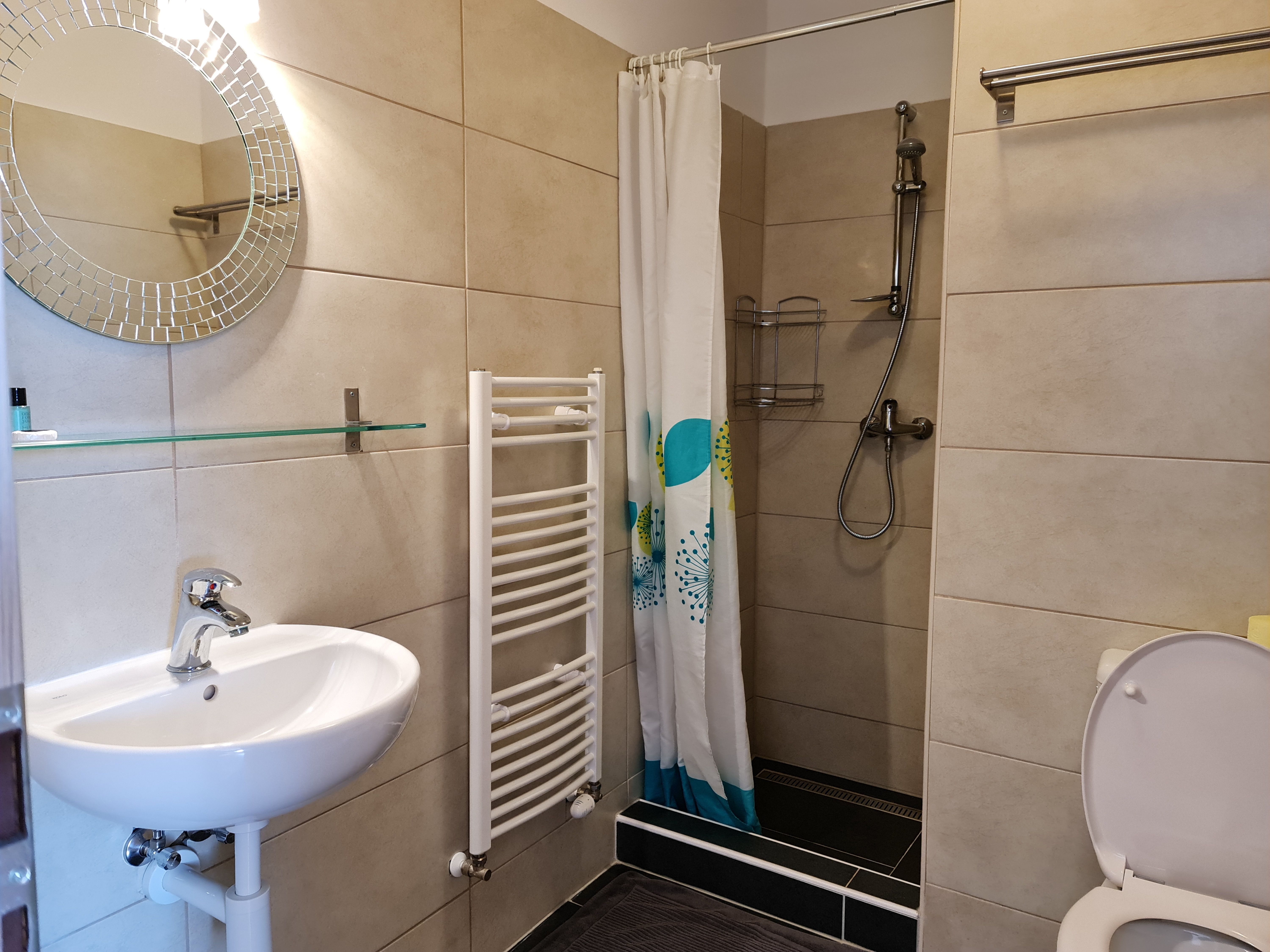 Modernes Badezimmer mit Dusche, Waschbecken und Toilette.