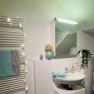 Modern bathroom with washbasin, mirror, towel rail and decorations.