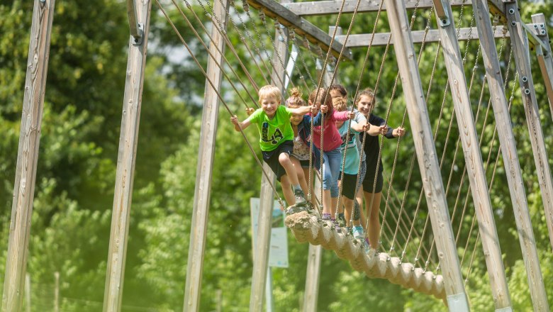 Kinder auf einer Hängebrücke im Motorikpark St. Corona.