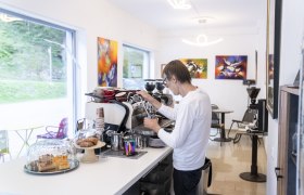 Barista prepares coffee in a modern caf&eacute;.