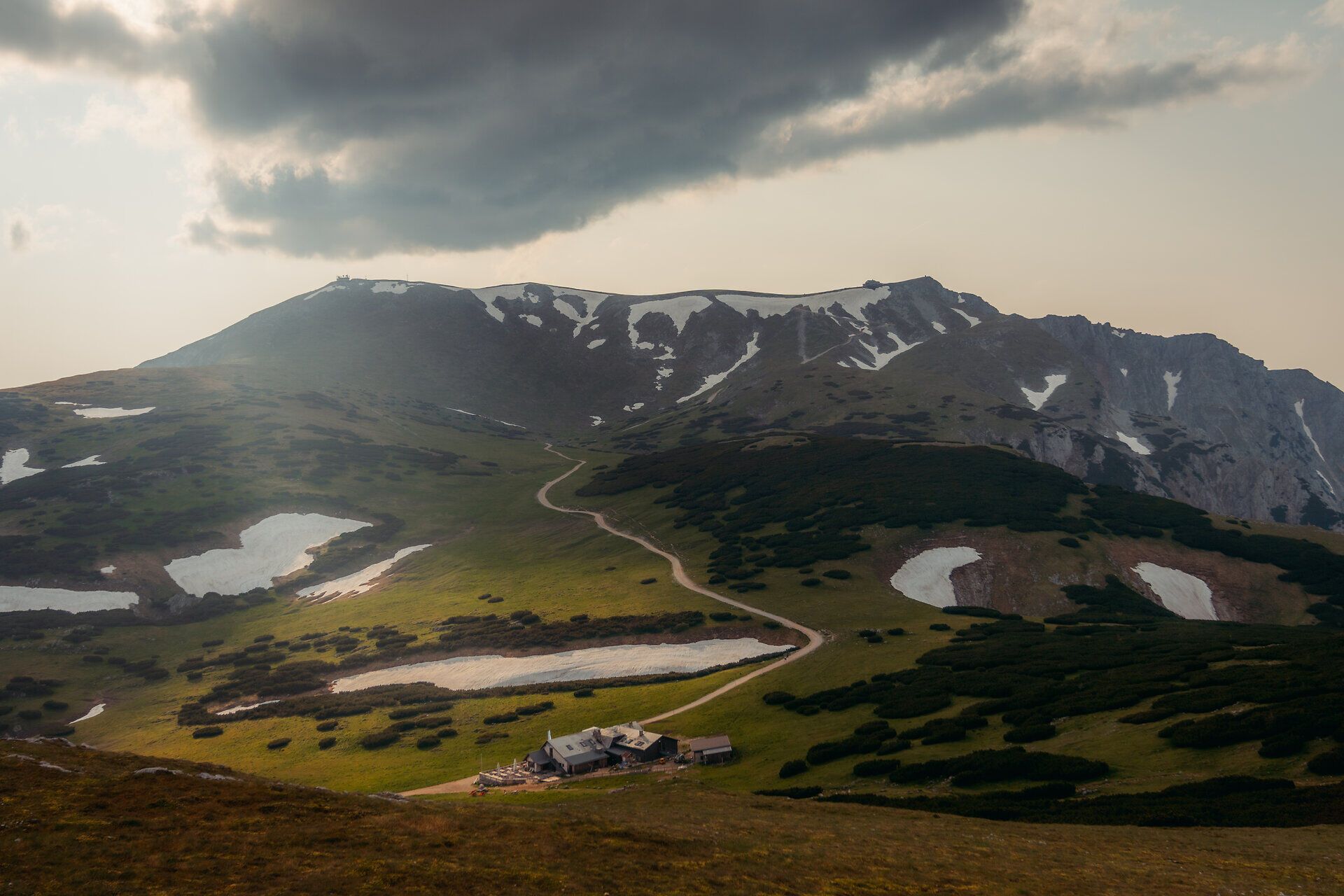 Die sanften Hügel und schneebedeckten Gipfel laden zu unvergesslichen Erlebnissen in der Natur ein. Grüne Wiesen und glitzernde Bergseen schaffen eine malerische Kulisse für Wanderer und Naturliebhaber. Hier entfaltet sich die Schönheit des Bergsommers in voller Pracht.