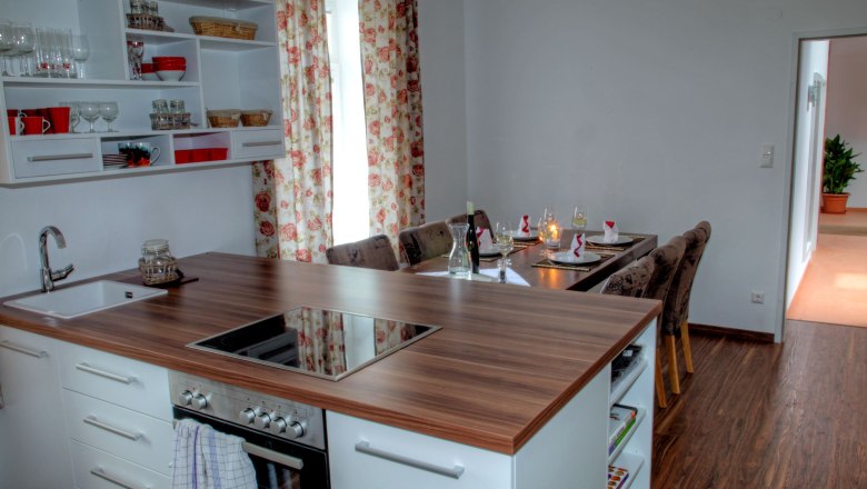 Moderne Küche mit Esstisch in einem Loft, dekoriert mit Blumenmustervorhängen.