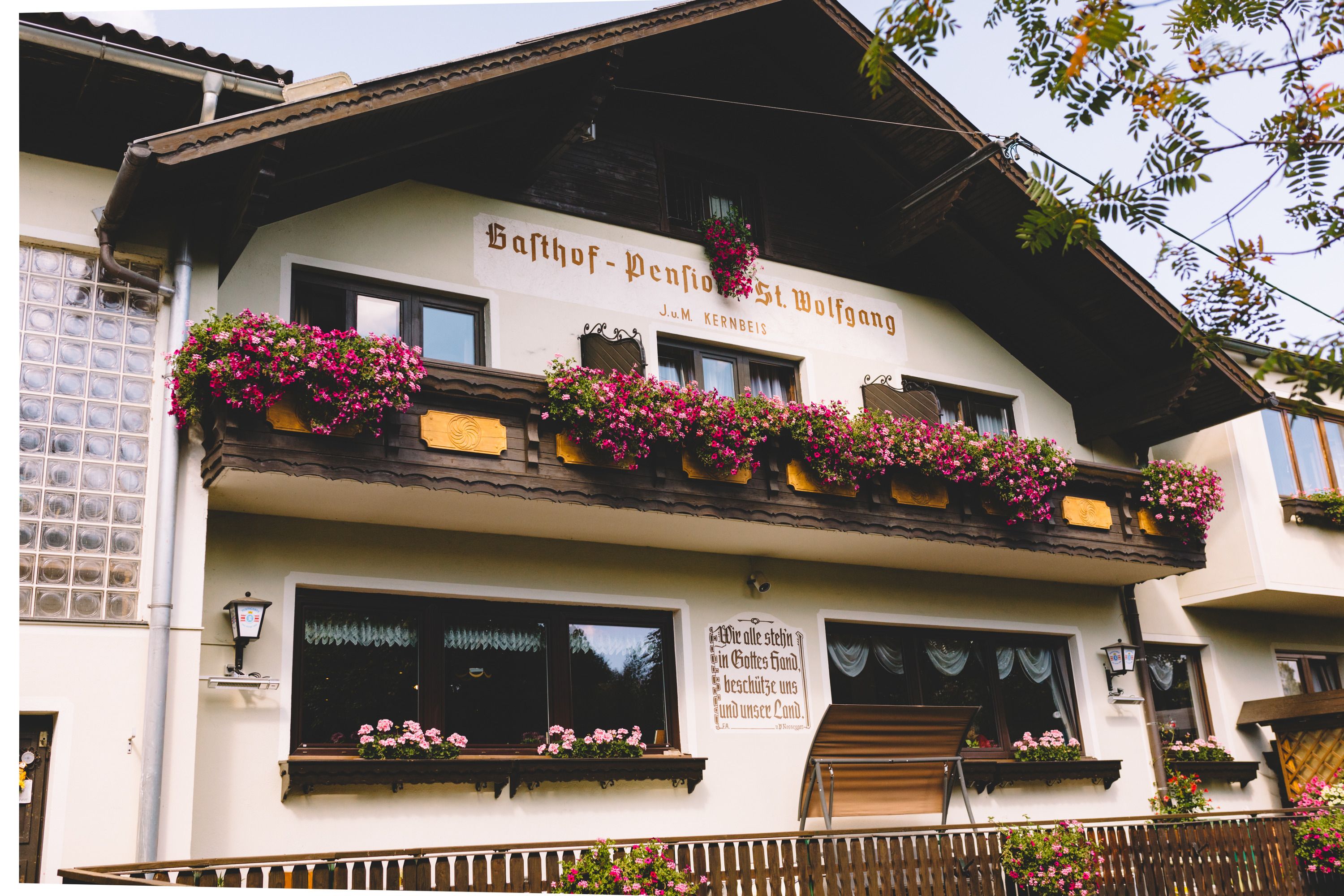 Gasthof-Pension St. Wolfgang mit Blumen geschmücktem Balkon in Kirchberg am Wechsel.