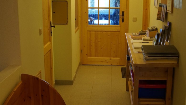Ein Flur mit Holzmöbeln, Informationsmaterial und Spielen.