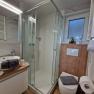 Modern bathroom with shower, washbasin and toilet.