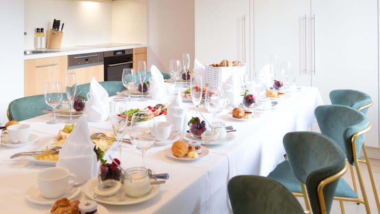 Elegant breakfast table in modern kitchen with laid table, crockery and dishes.