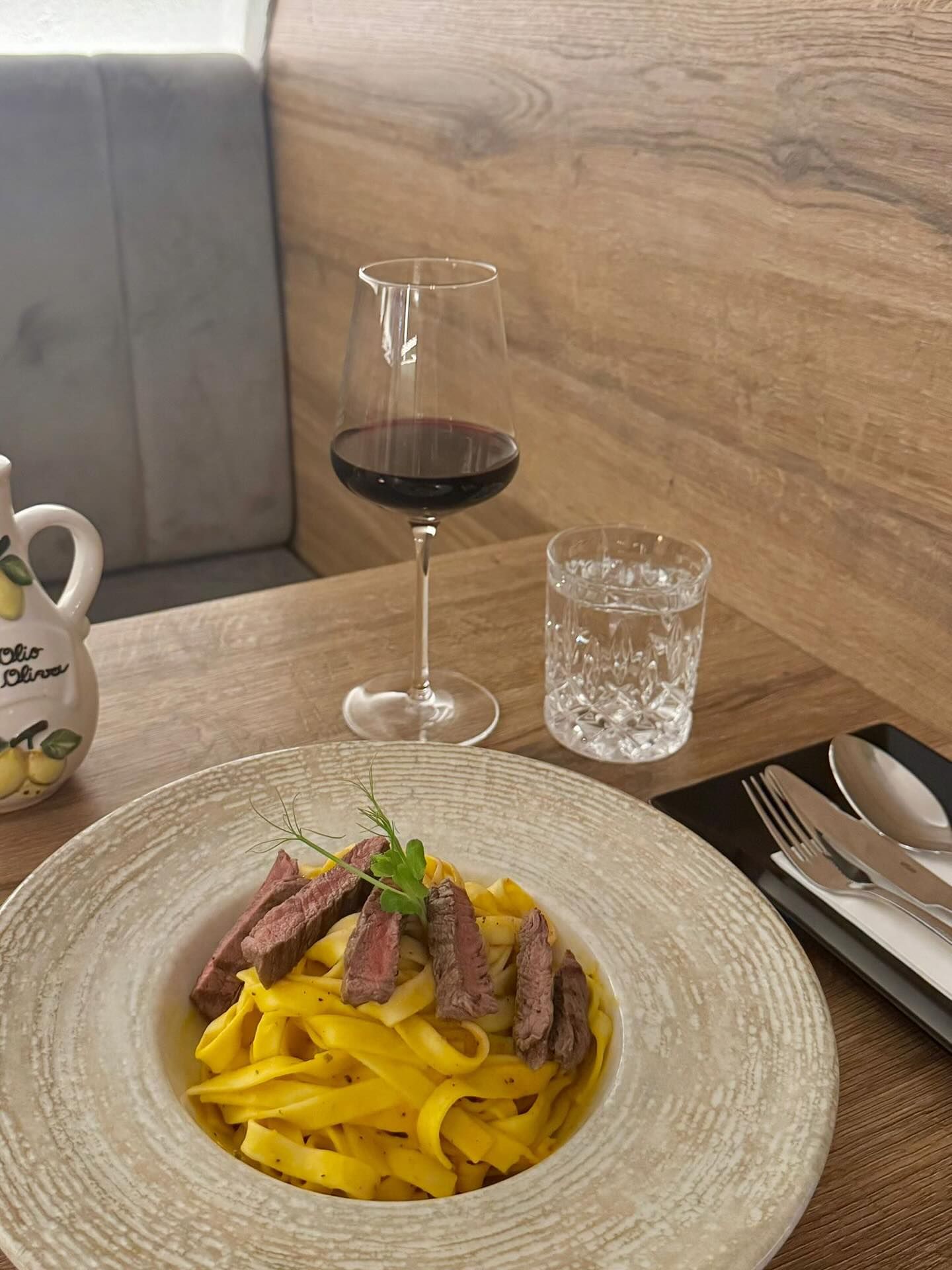 Teller mit Nudeln und einem Glas Rotwein