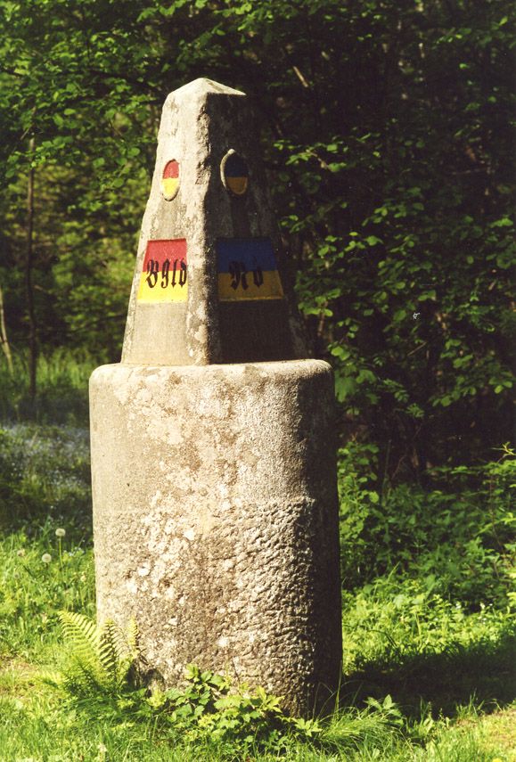 Ein Dreiländerstein im Wald, der die Grenze zwischen Burgenland, Niederösterreich und Steiermark markiert.