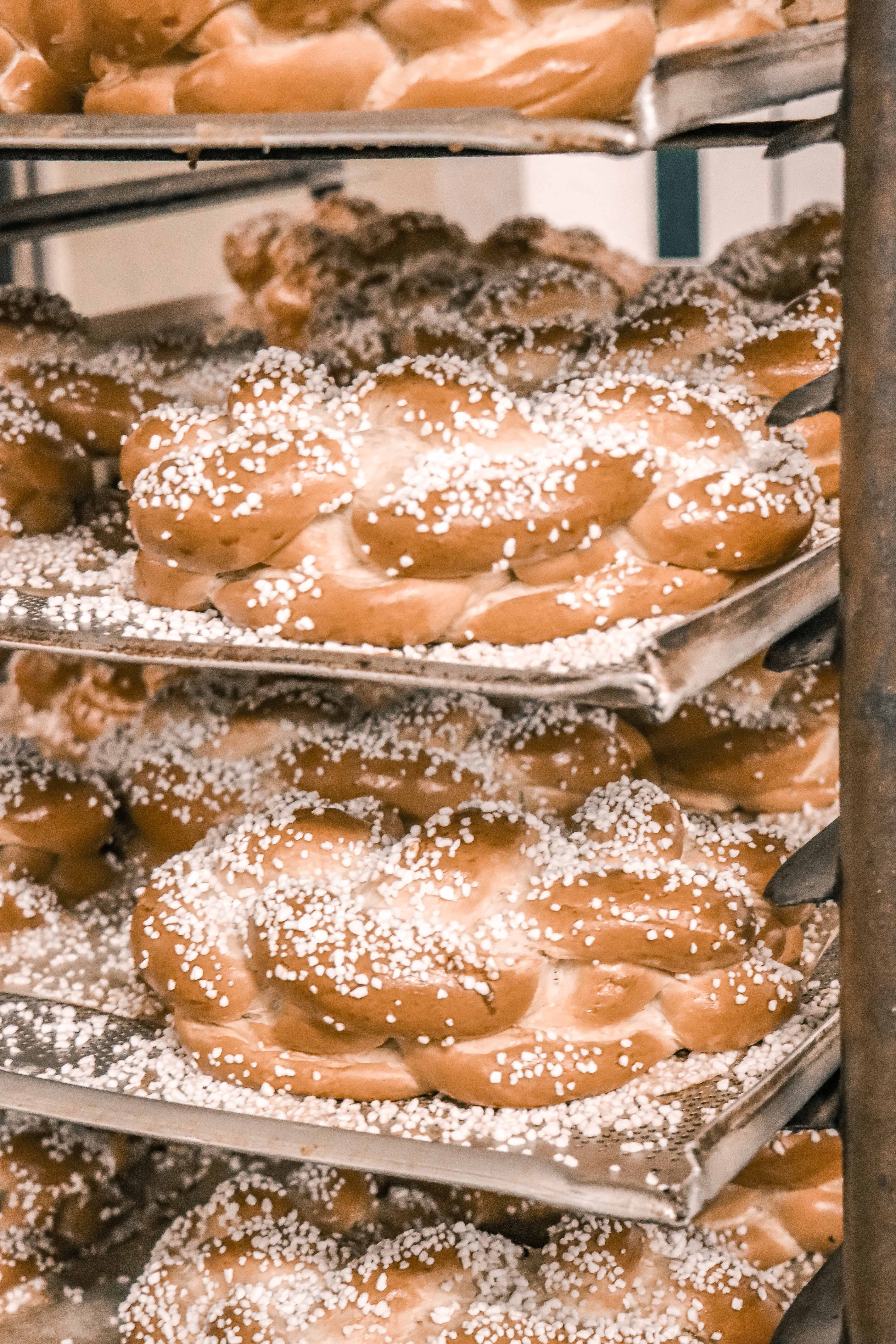 Backbleche mit Striezel, die mit Hagelzucker bestreut sind.