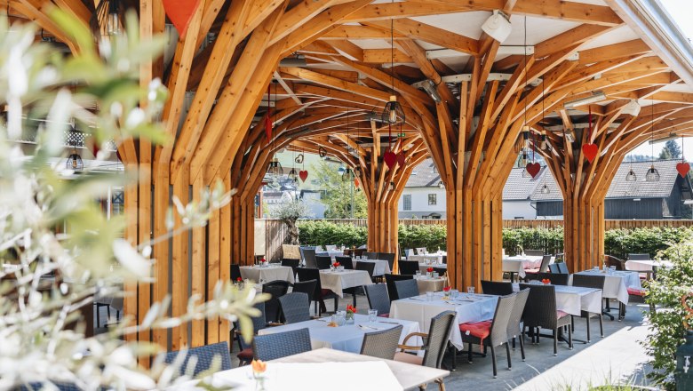 Modern guest garden with wooden construction and covered tables.
