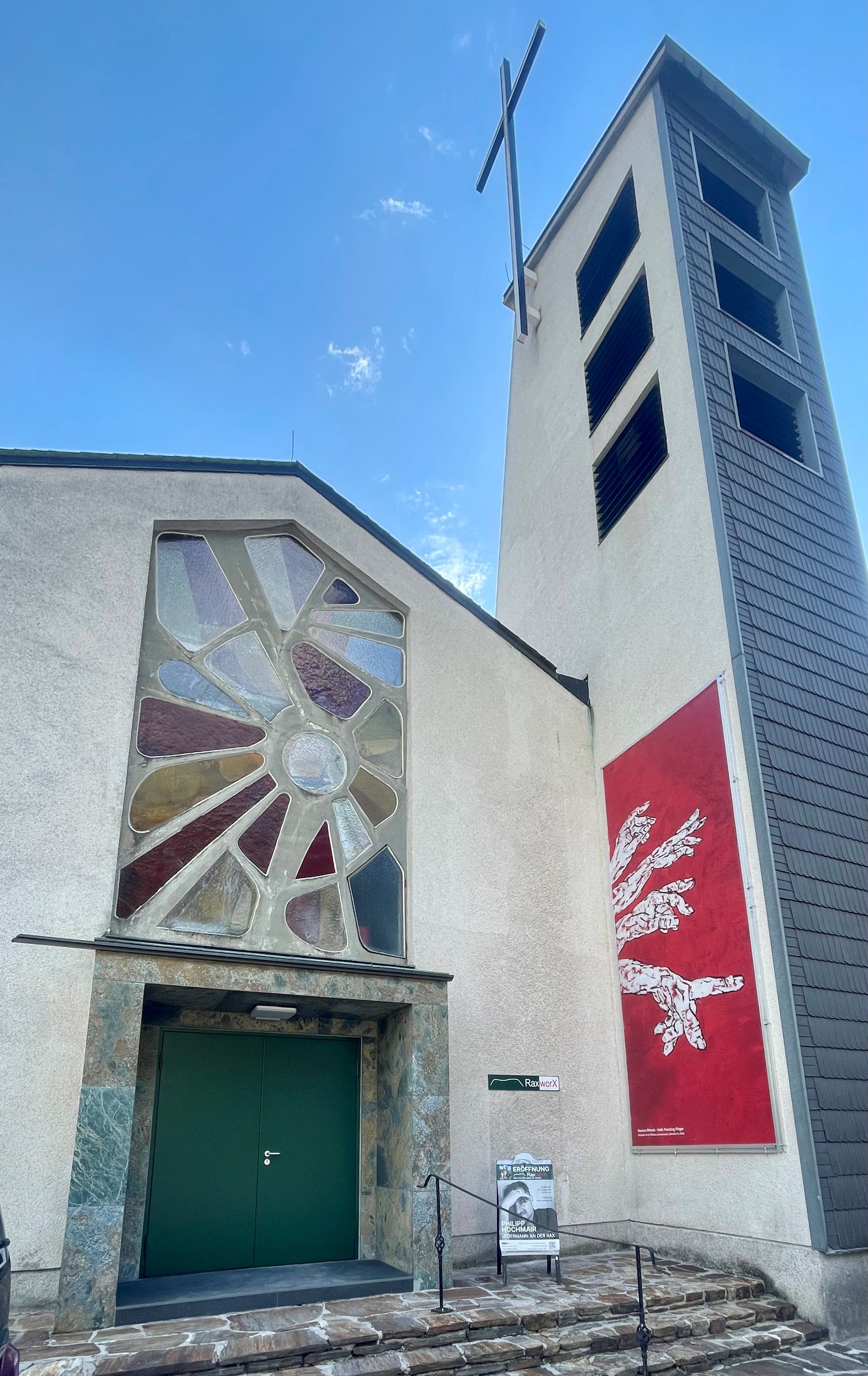 Former church with a modern stained-glass window and bell tower