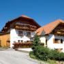 A traditional country inn with a wooden façade and flower boxes under a blue sky.
