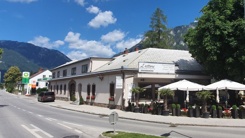 Ferienwohnung L'attore, © L'attore Reichenau Straßenszene mit Restaurant L'attore und Bergen im Hintergrund.